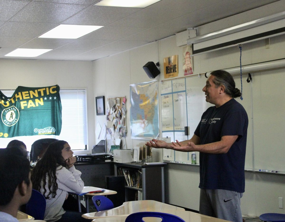 Standing in front of the room, Professor Madril speaks to an ethnic studies class in the portable classrooms at Redwood. 