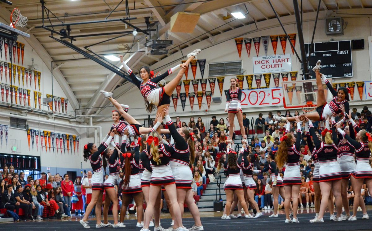  Facing the senior section, varsity cheer shows off their flexibility and strength.
