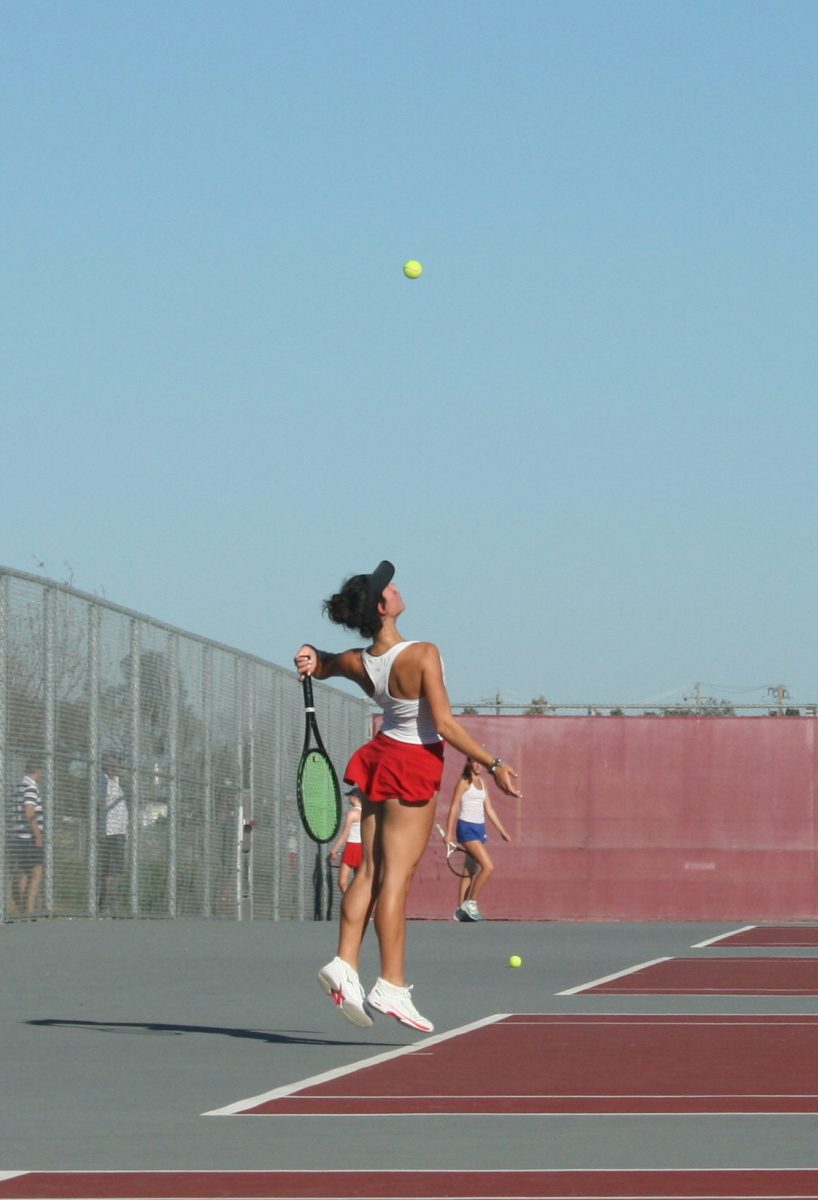 Jumping for maximum power, freshman Julia Povio gets ready to serve her opponent.