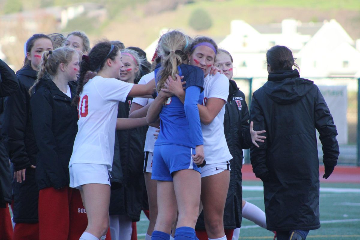 Senior Ellie Kemos comforts a Tam player after the emotional game.