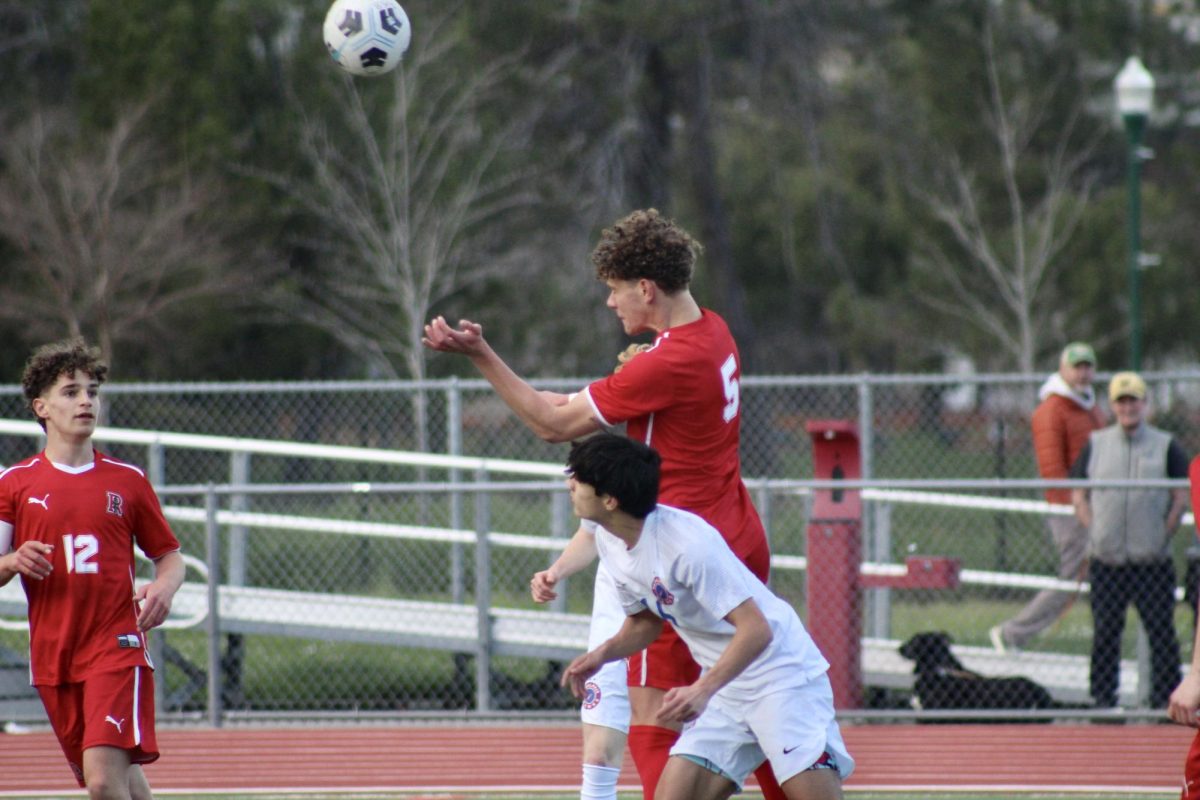 Making contact with the ball, senior Ensio Sardans jumps above his opponent. 