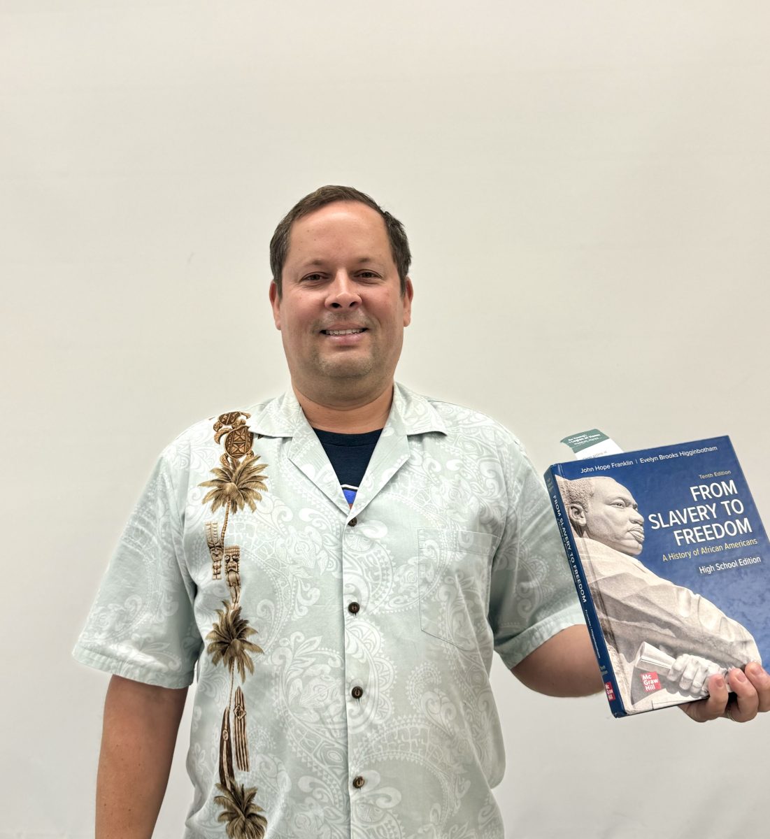 Posing with the AP African Studies coursebook, Mr. Butkevich holds his book with pride.