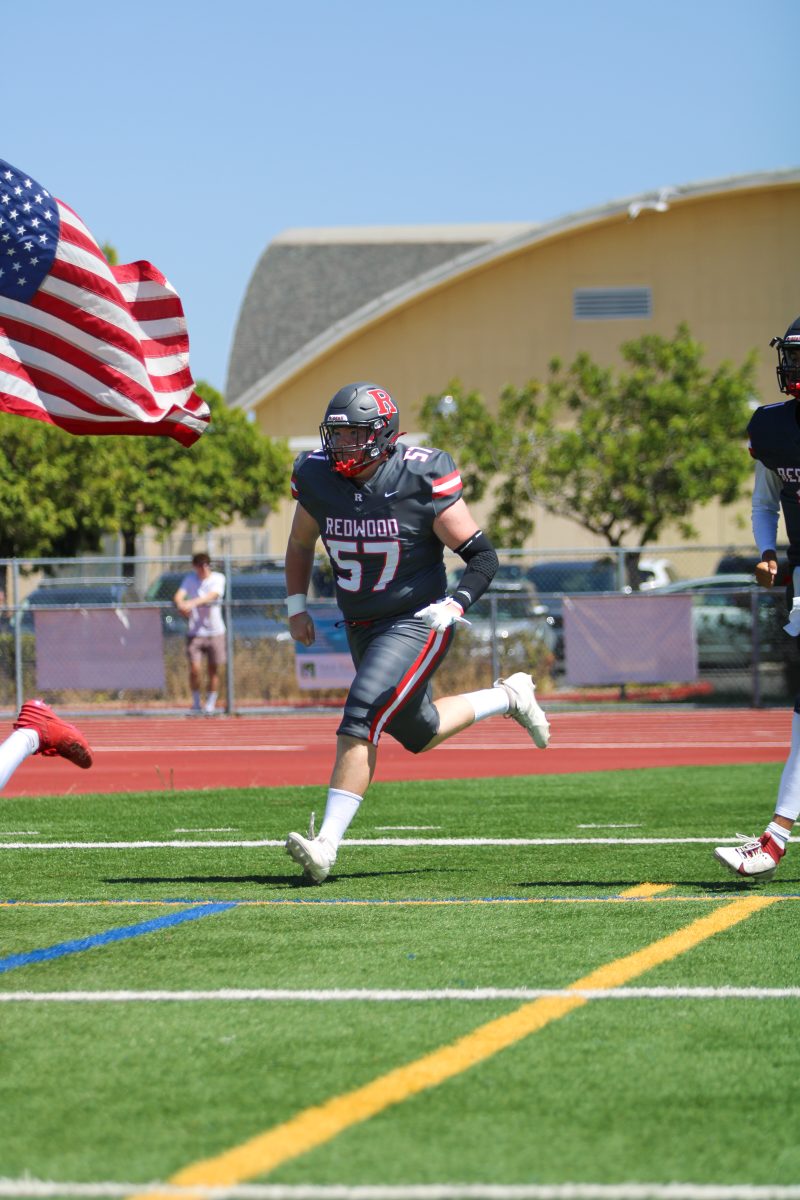 Jack McKemey runs on onto the field prior to Redwood's season opener against San Leandro.