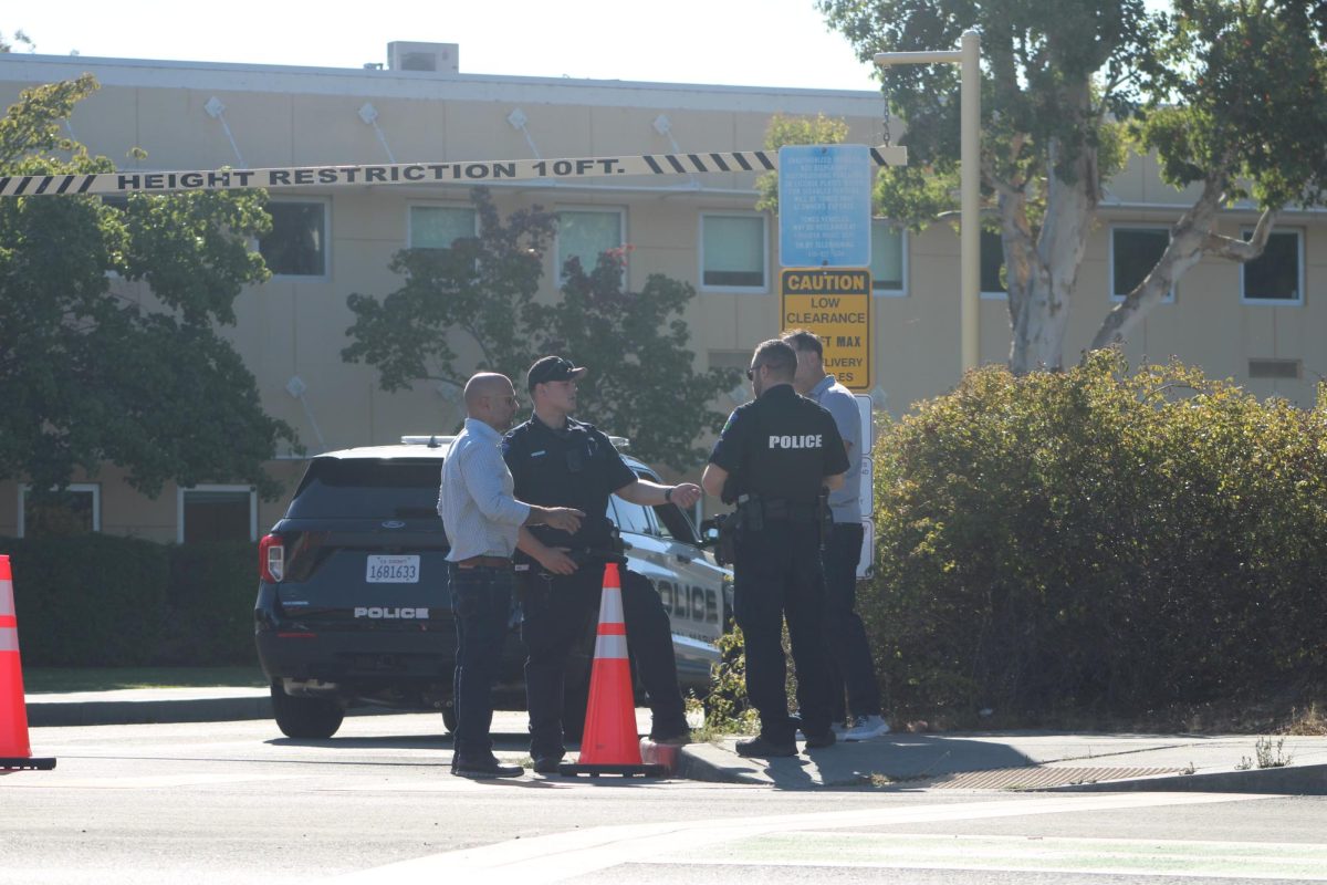 Assistant Principal Saum Zargar discusses plans with police officers outside of Redwood’s front parking lot.