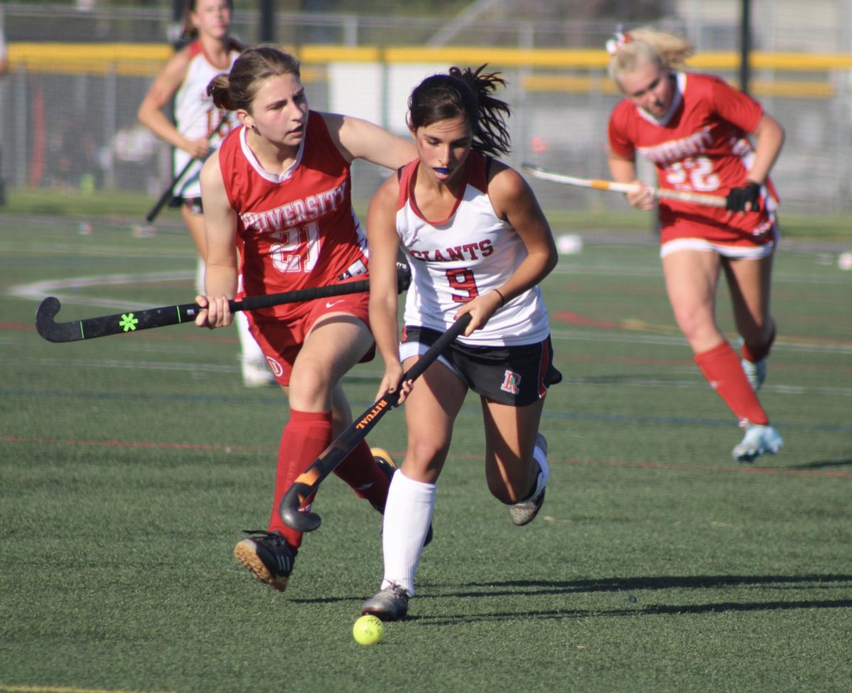 Fighting off intimidation tactics by a University High School forward, senior Jane Broderick (9) races after the ball.