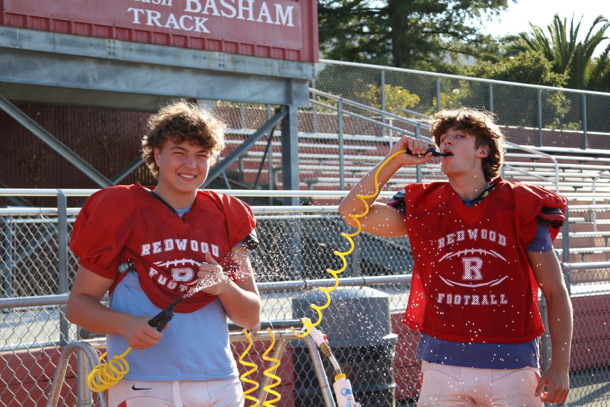 Cooling off and staying hydrated during a hot practice, Sophomores Max Ivey and Charlie Anderson utilize the water horse