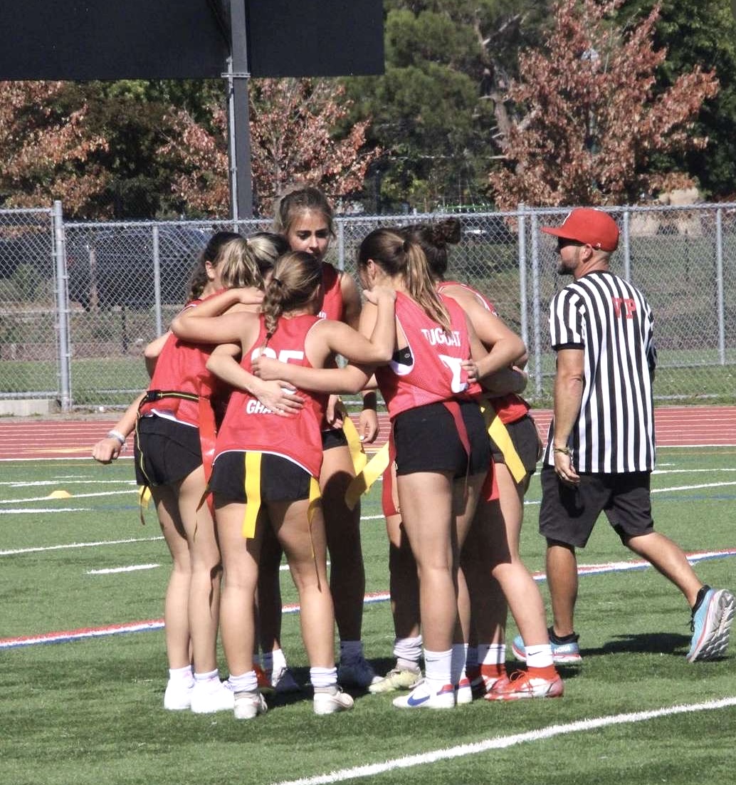 2023 Powderpuff game: Junior girls strategizing their next play (courtesy of Presley Pewitt)