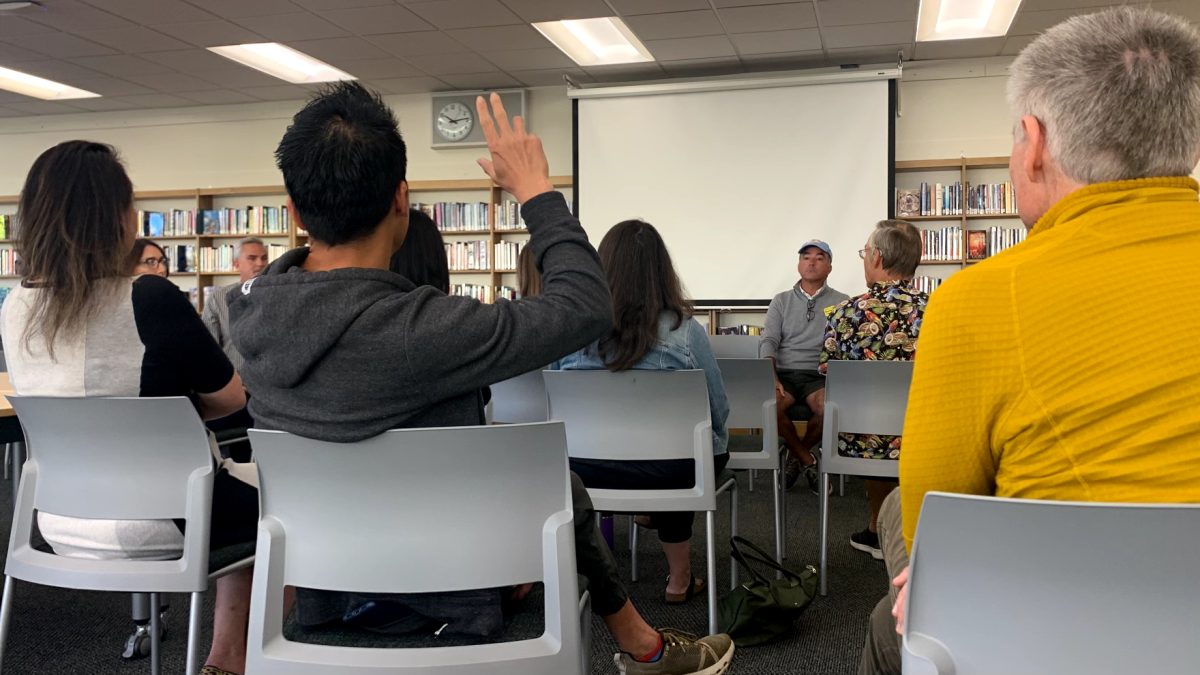 Raising their hand, the focus of the room turns toward a parent who questions the effectiveness of the Yondr pouch policy versus the current phone caddy mandate.