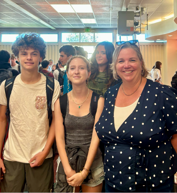 Standing with two sophomore students in the cafeteria, Ms. Vester pauses for a photo while managing lunch lines in the cafeteria 