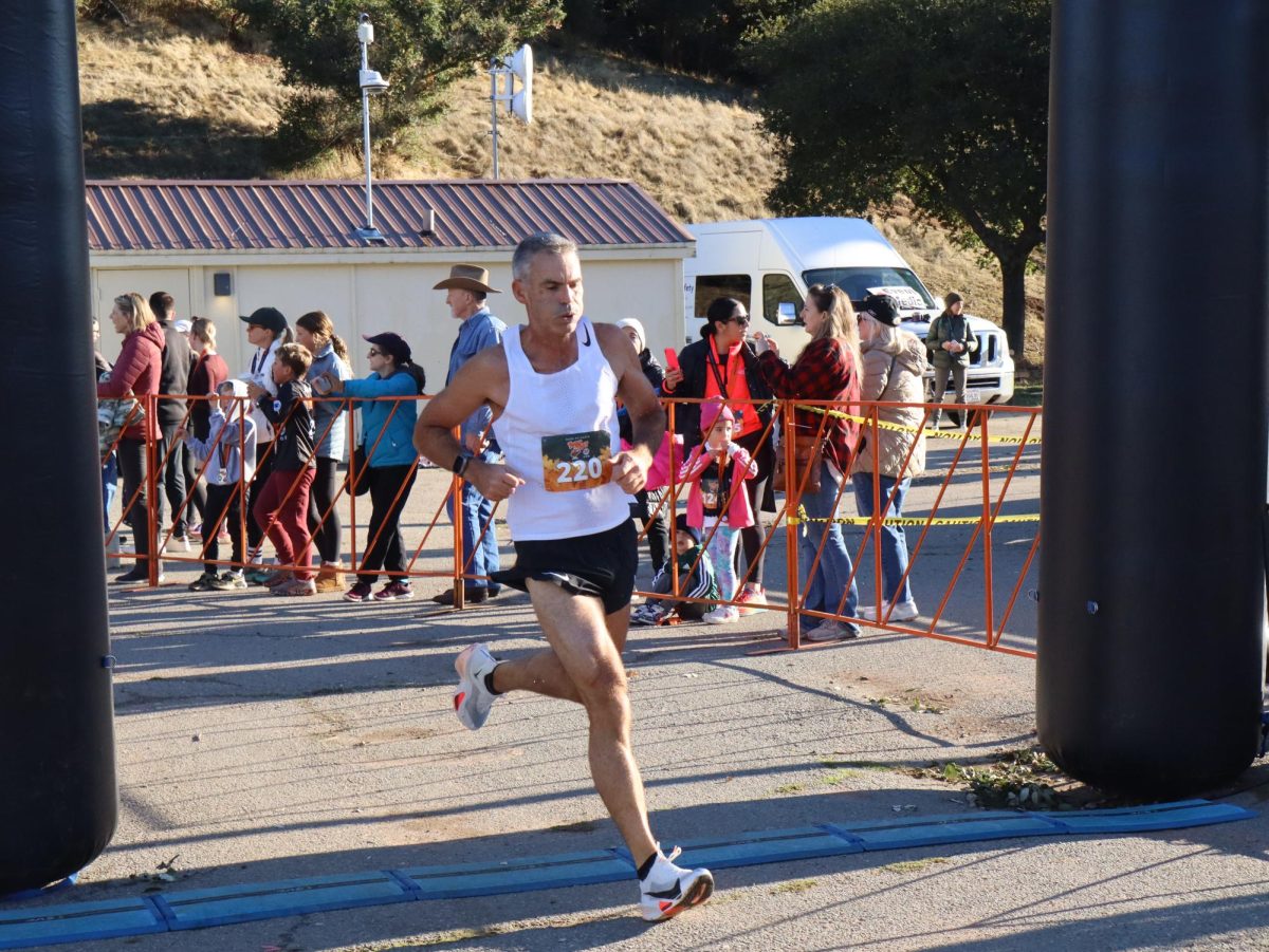 Murray Dunn ran into the finish to place second overall in the 10K with a time of 38:57, an intense expression on his face.