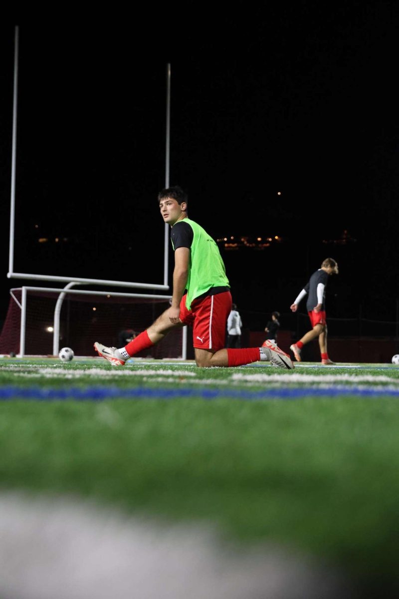 Warming up legs for the game, senior captain Sam Gersch does his game-day rituals.