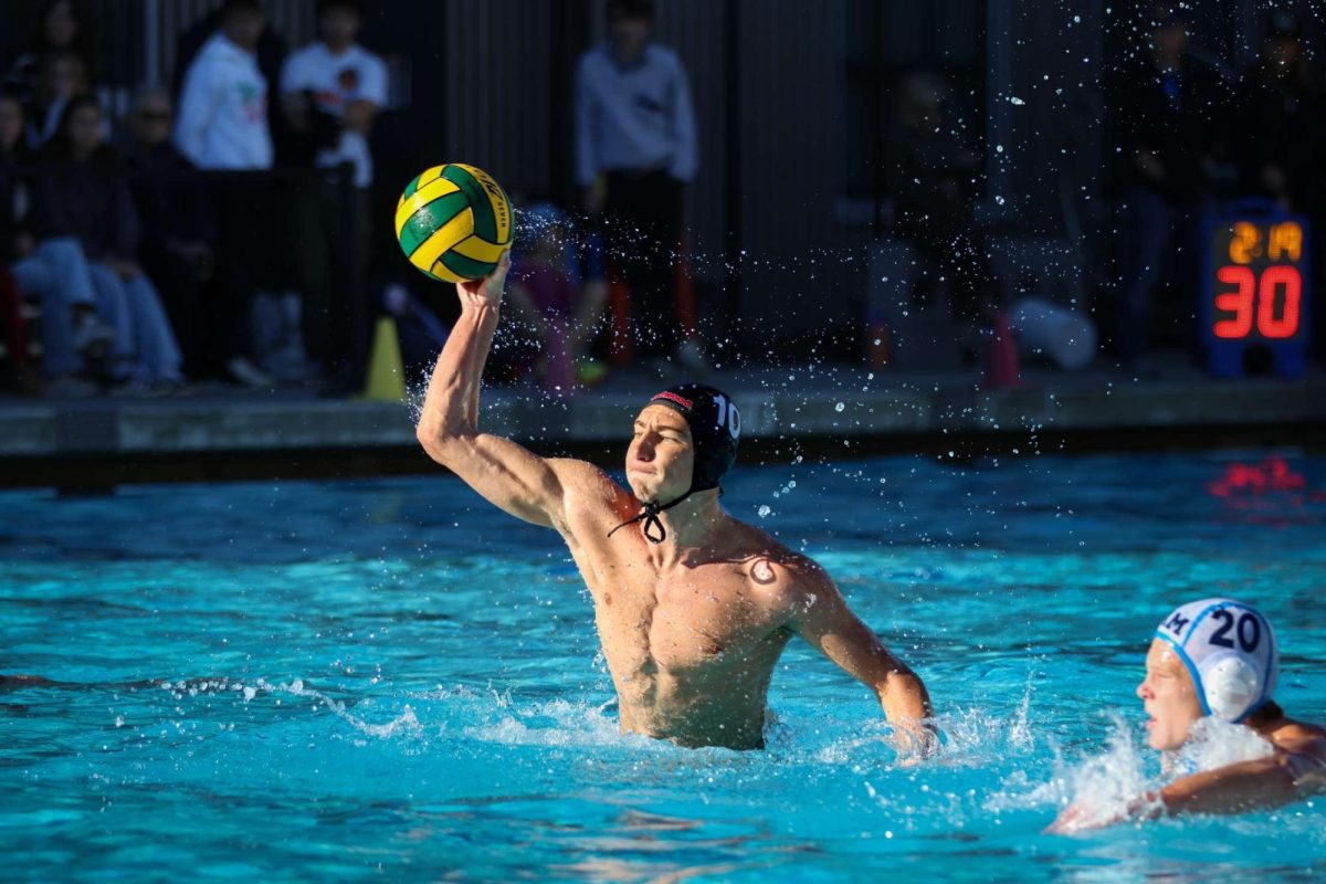 Senior Sawyer Goldberg rises out of the water to take a shot on goal.