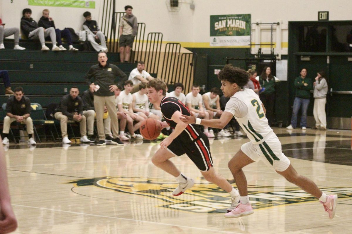 Dribbling down the court, Brennan Woodley speeds past a San Marin defender. 
