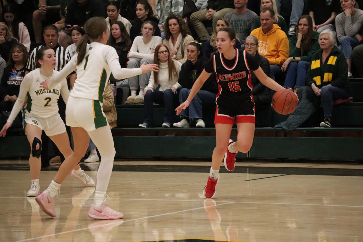 Leaping in the air, senior Maya Saibel zig-zags around the opposing team to shoot.
