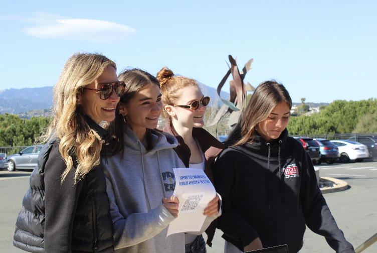 On Jan. 26, Teen Service Corps (TSC) leaders, Gigi Walravens, Jamie Glennon and Renata Lionetti pose for a photo, holding up their clothing drive Venmo QR code, where all proceeds will go to survivors of the Los Angeles fire.