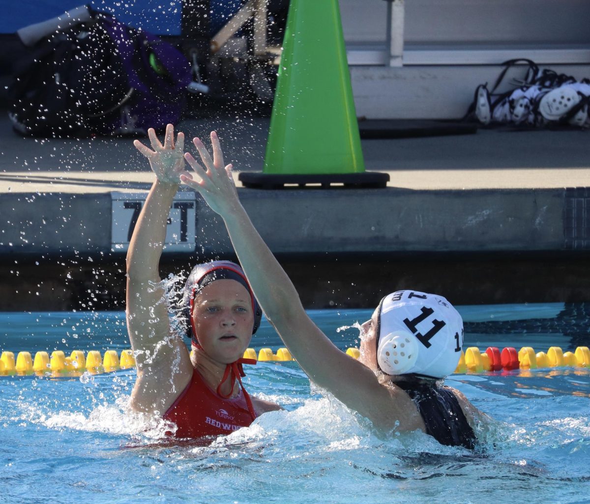 Sophomore Lily Kilgore throws a pass over the opponents head.