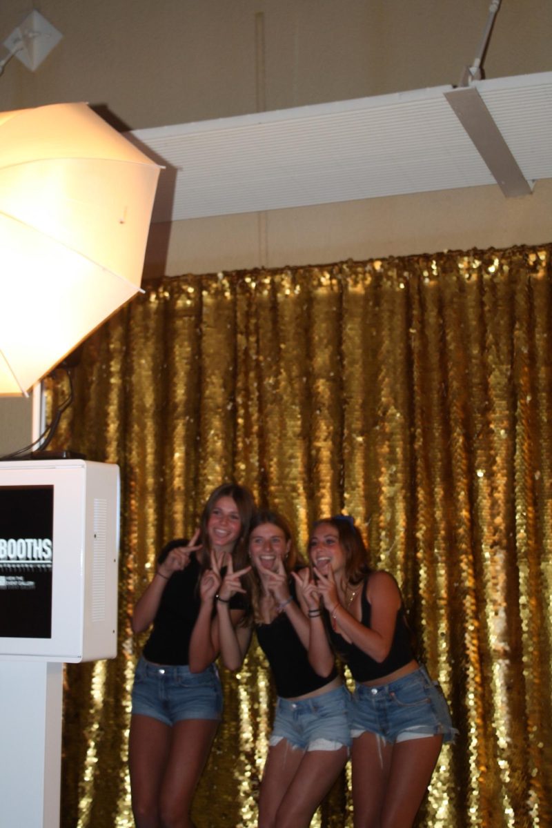 Friends strike a pose in the photo booth, one of several activities offered alongside the dance.