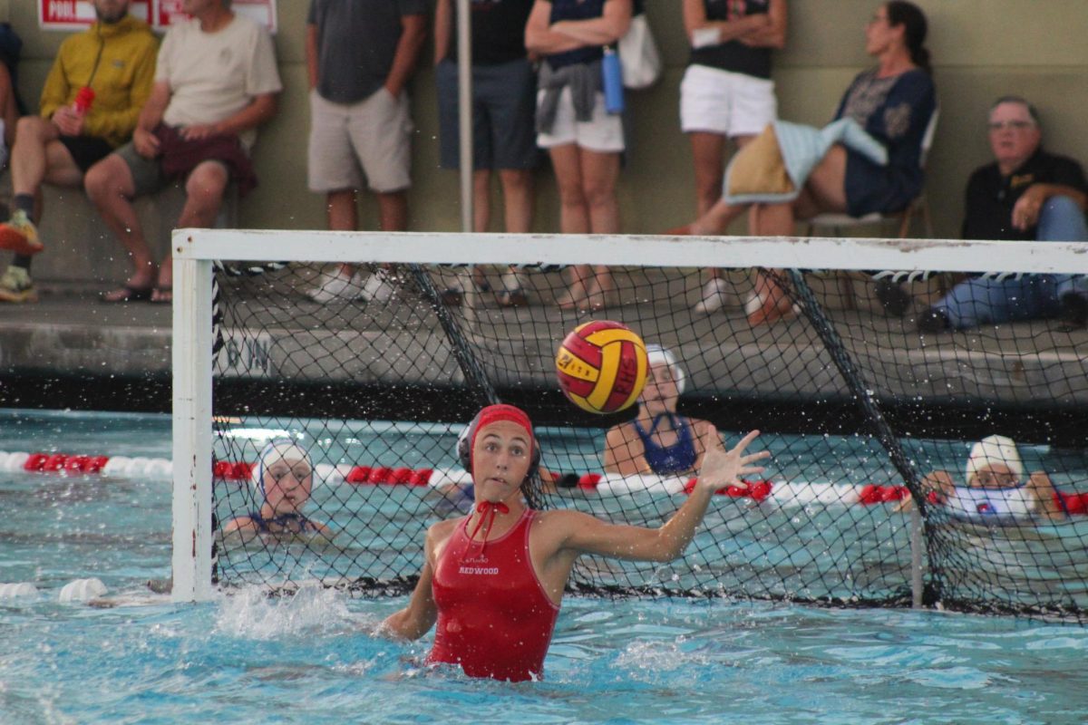 Junior Aurora Devilbiss, goalie, frantically reaches unsuccessfully to block the ball from entering the goal.

