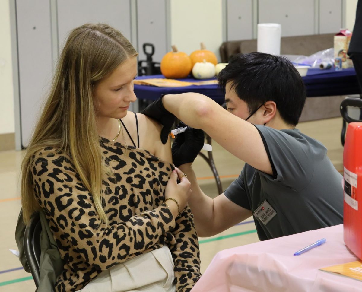A nurse administering vaccines for Safeway gives a flu shot to a community member.