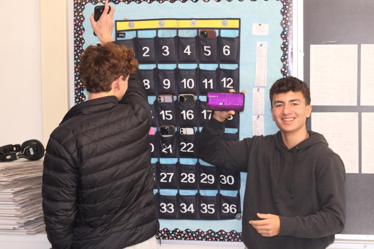 Sophomores John Steinhart and John Biel put their phones up before their SMART period on Friday, Dec. 12.
