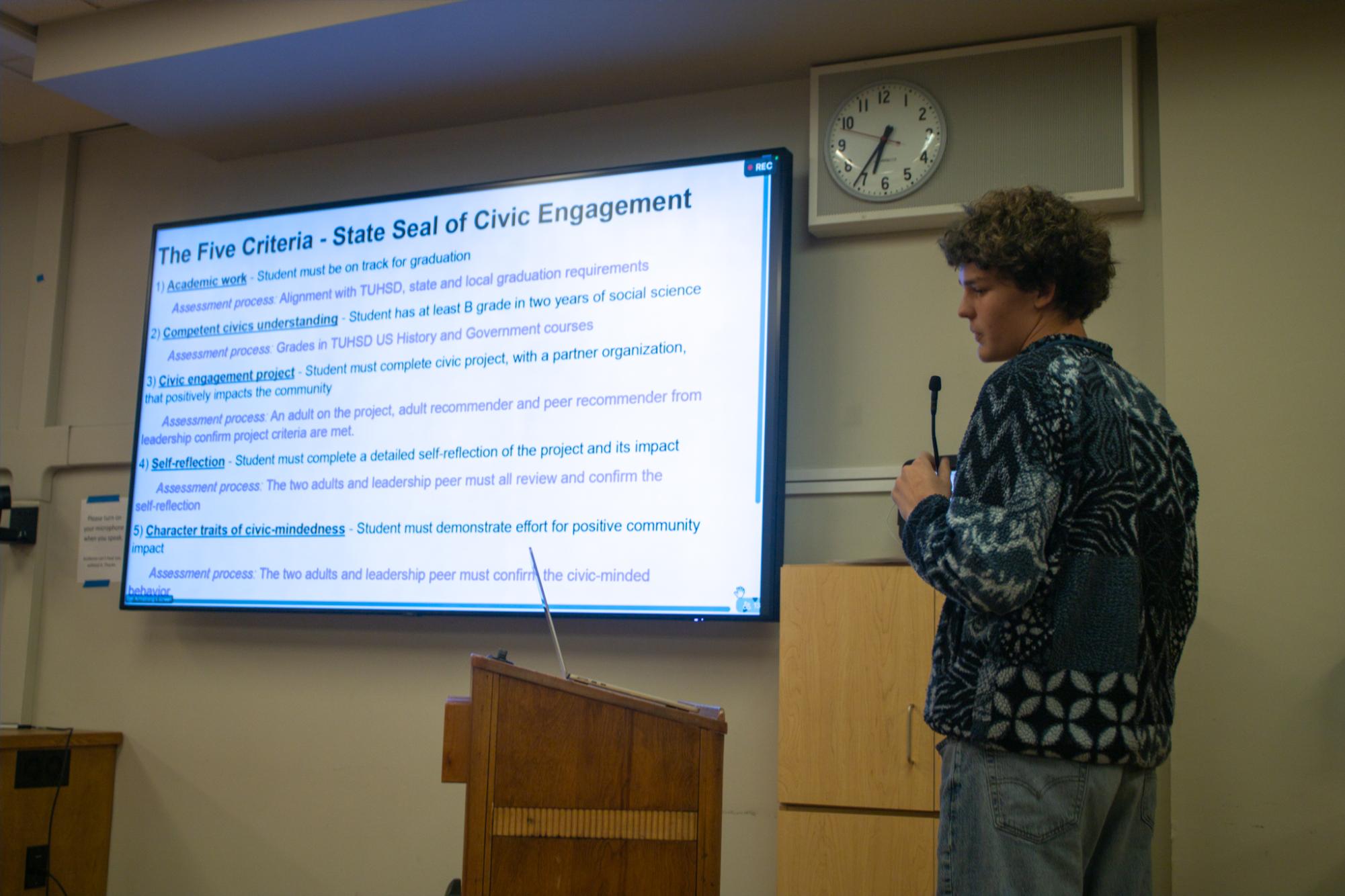 Junior Everett Fredericks presents his proposition to add the State Seal of Civic Engagement to the district board.