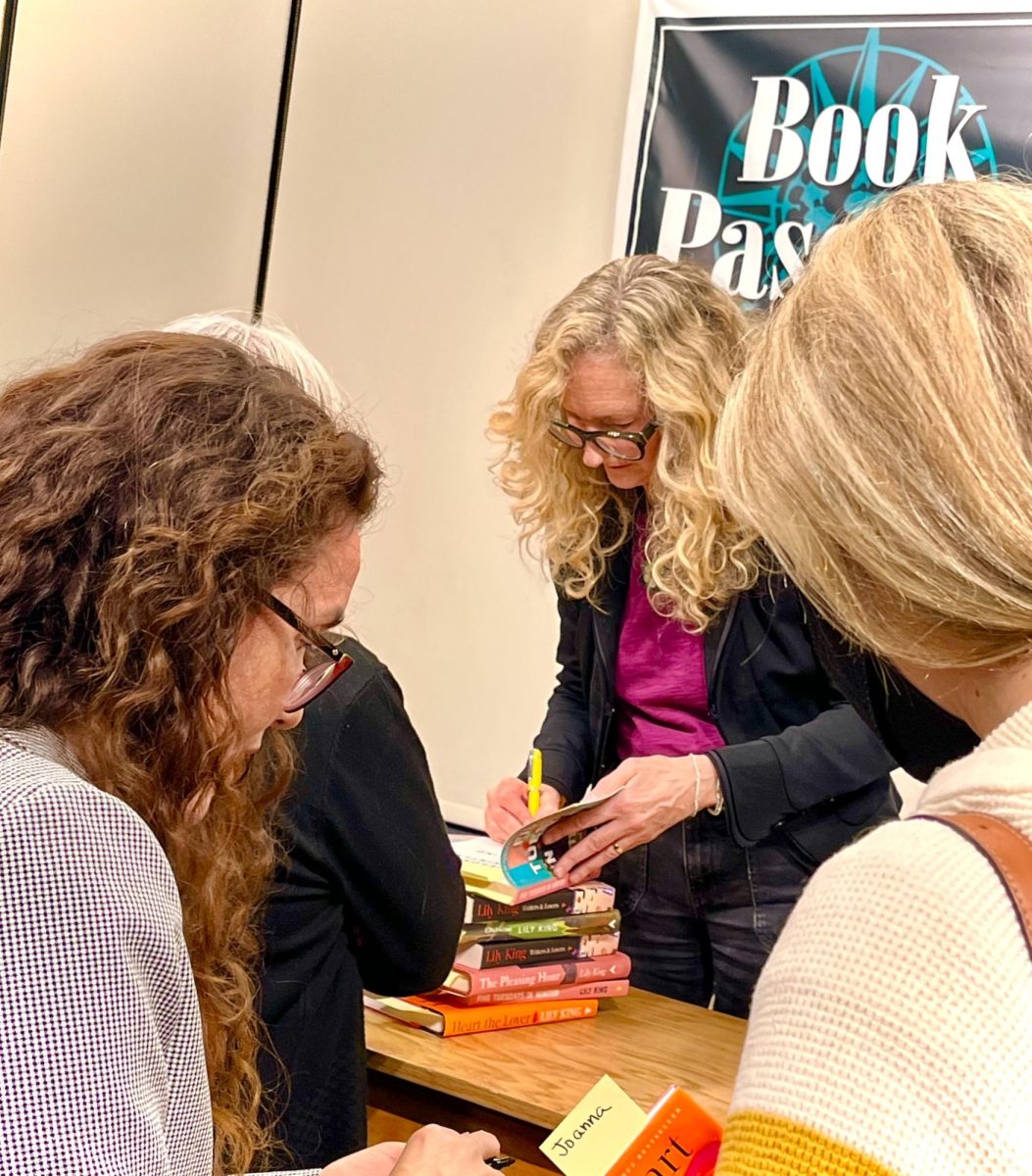 Lily King signs copies of her books following her book talk with personal messages.