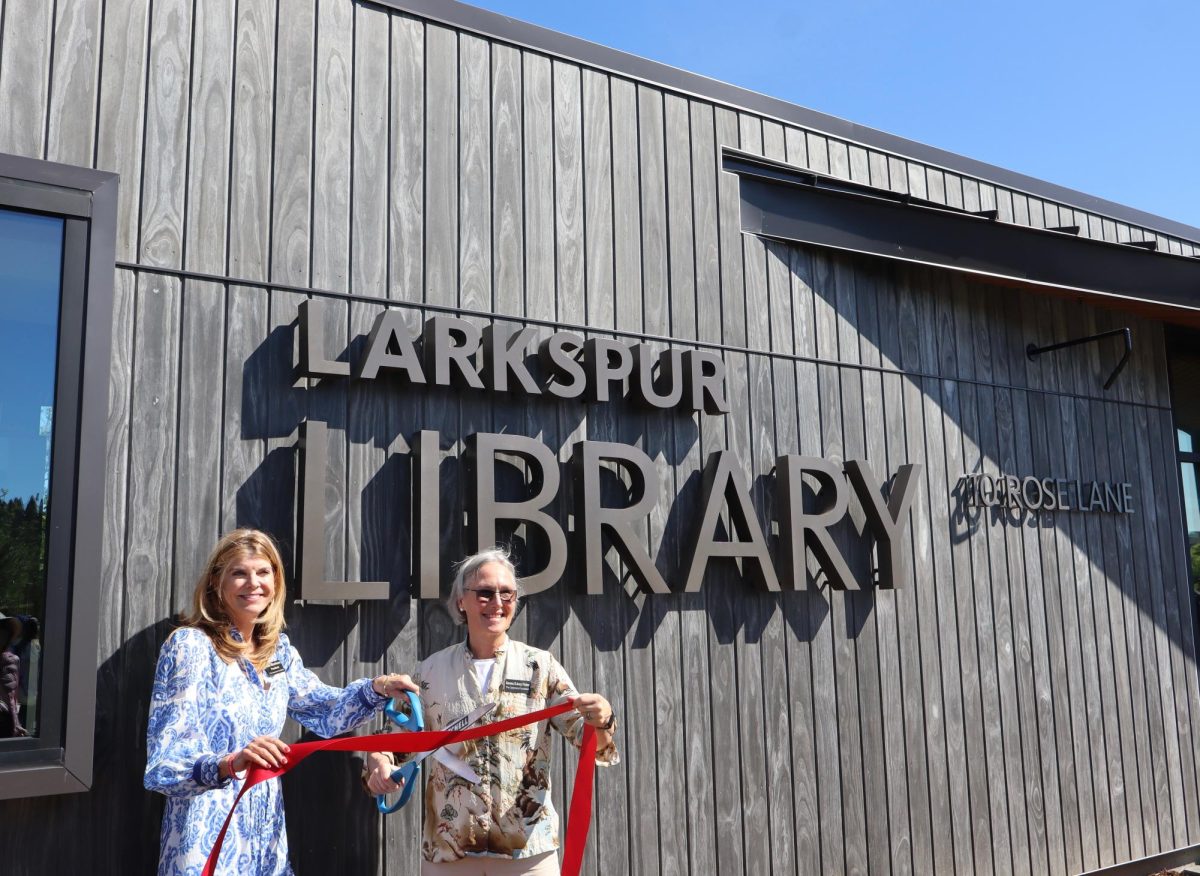 Ann Morrison (left) and Serena D’Arcy Fisher (right) from the Commons Foundation cut the red ribbon during the grand opening of the Larkspur Library.