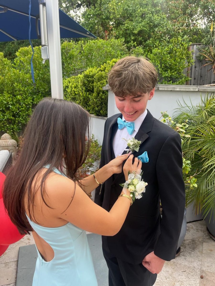 Placing a boutonniere on her date Schuyler Coletta, Erin Macmillin prepares to celebrate Prom. (Courtesy of Erin Macmillin)