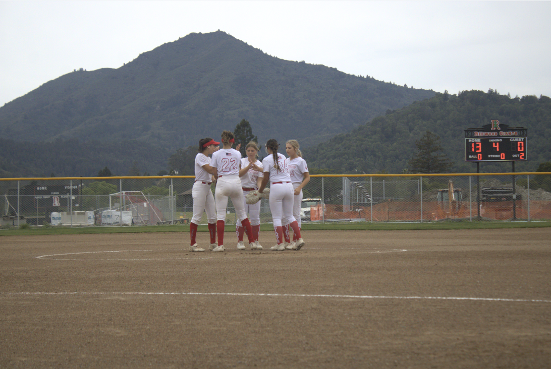 The infielders gather at the pitcher's plate to high-five after the second out of the fourth inning, pitched by freshman Desmina Marcus.
