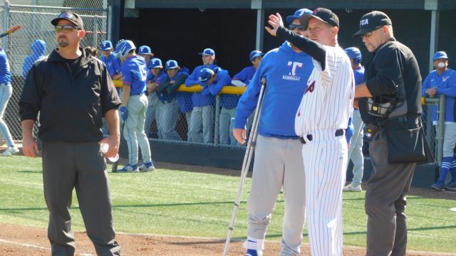 Redwood manager Mike Firenzi meets with the umpires prior to the game.