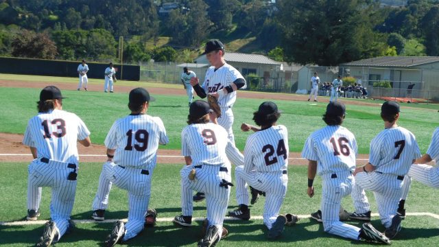 The Redwood boys’ baseball team cheers on their teammates as they finish warmups.