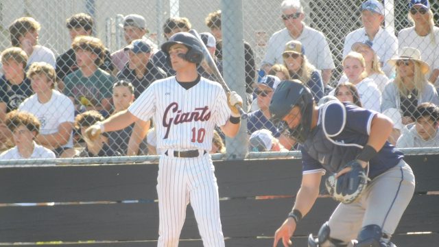 Stepping back, Sam Gersch watches as the Wildcat catcher scurries for the ball.